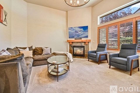 A living room with a fireplace and a painting on the wall.