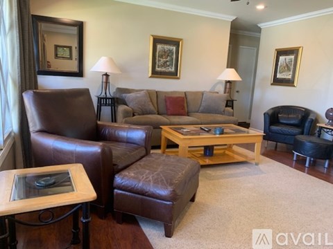 A living room with brown leather furniture and a wooden coffee table.