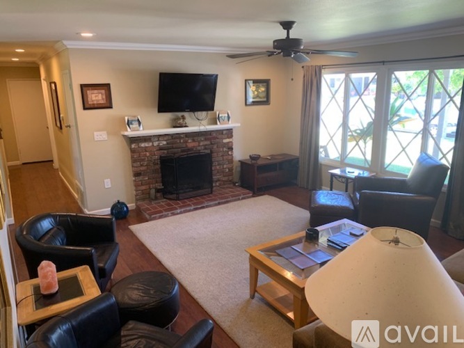 A living room with a fireplace and a flat screen TV mounted above it.