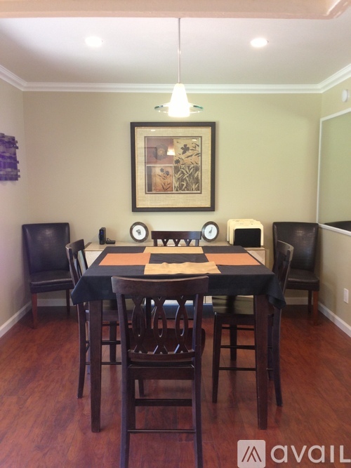 A dining room with a table set for six people.