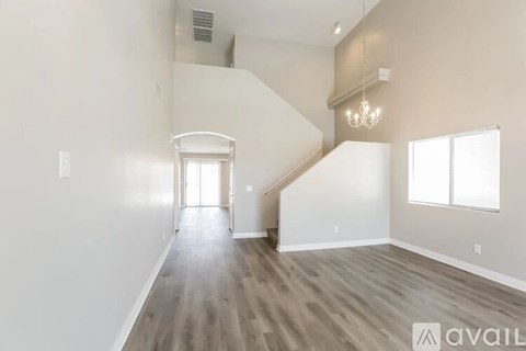 A spacious room with a staircase leading to the upper level.