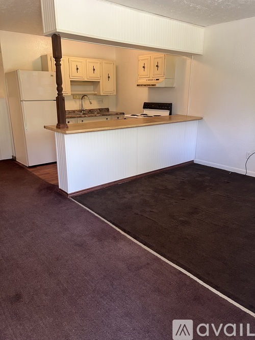 A kitchen with a white fridge and cabinets.
