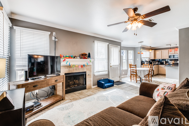 A living room with a fireplace and a television on a stand.