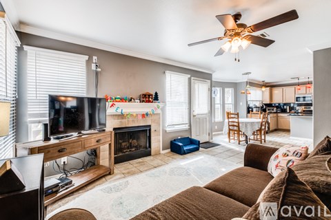 A living room with a fireplace and a television on a stand.