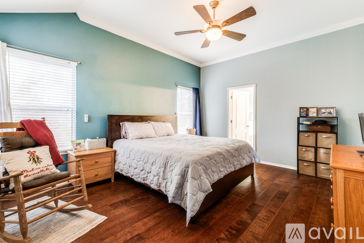 A bedroom with a bed, dresser, and rocking chair.
