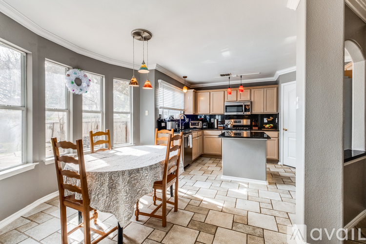 A kitchen with a table and chairs in front of a window.