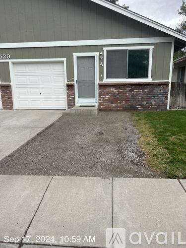 A house with a white garage door and a grey door is numbered 529.