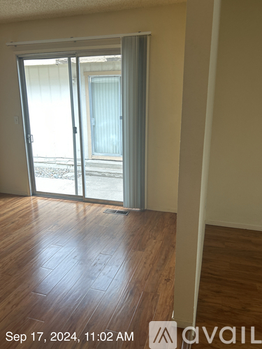A room with a wooden floor and a sliding glass door.