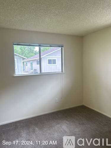 A room with a window showing a view of houses outside.