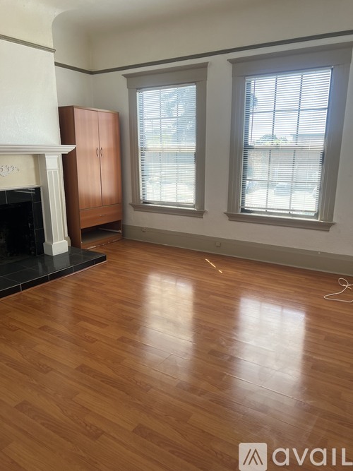 A room with a fireplace and wooden floors.