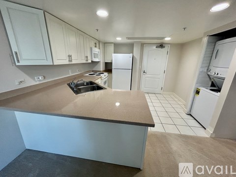 A kitchen with white cabinets and a brown countertop.