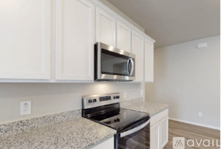 A kitchen with a granite countertop and white cabinets.