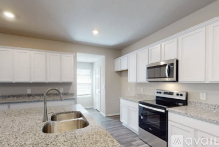 A kitchen with white cabinets and a granite countertop.