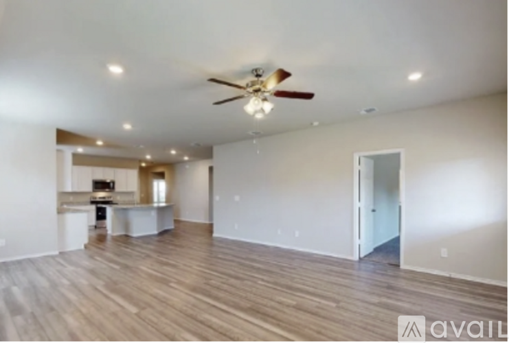 A spacious room with a ceiling fan and wooden flooring.