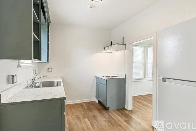 A kitchen with a sink and a refrigerator.