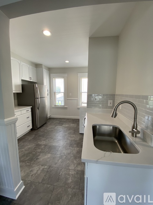 A kitchen with a sink and a refrigerator.