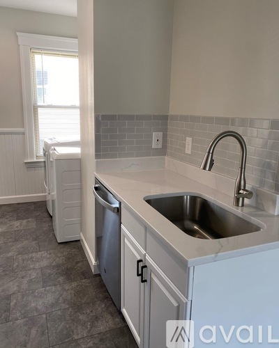 A kitchen with a stainless steel sink and a dishwasher.