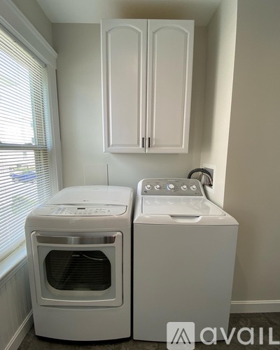 A white dryer and oven in a laundry room.