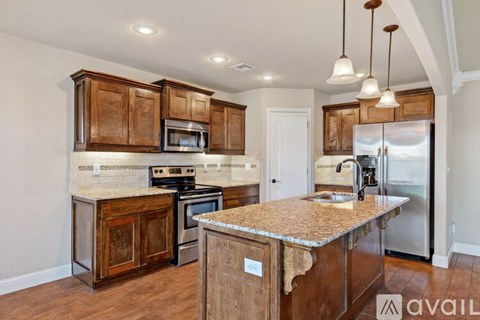 A kitchen with wooden cabinets and a granite countertop.