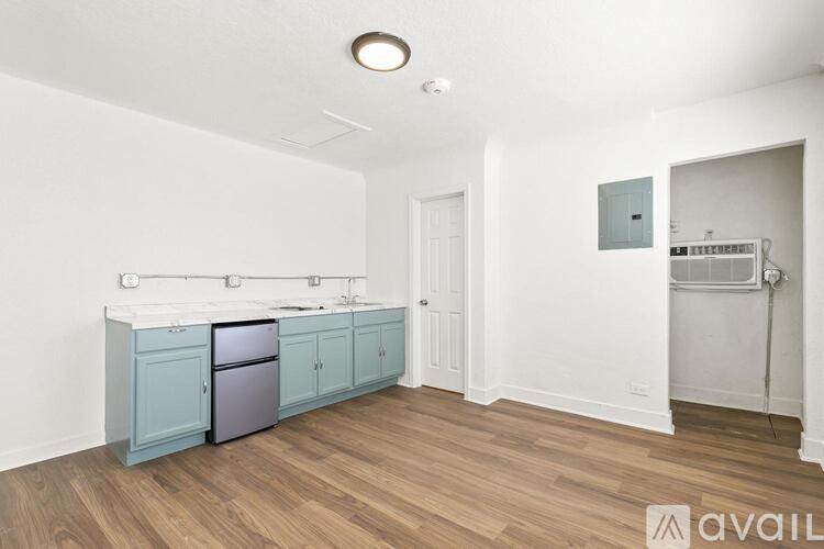A kitchen with a fridge, sink, and cabinets.