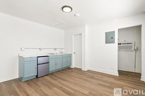 A kitchen with a fridge, sink, and cabinets.