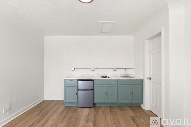 A kitchen with a white wall and a white door.