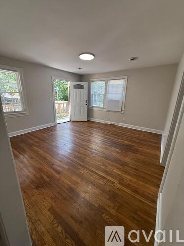 A room with wooden flooring and white walls.