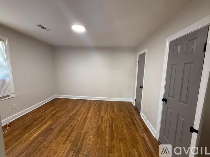 A room with wooden flooring and a white door.