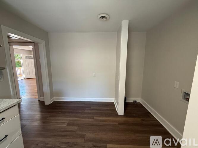 A room with wooden flooring and white walls.