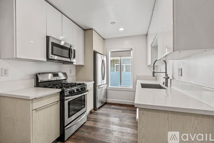 A modern kitchen with white cabinets and stainless steel appliances.