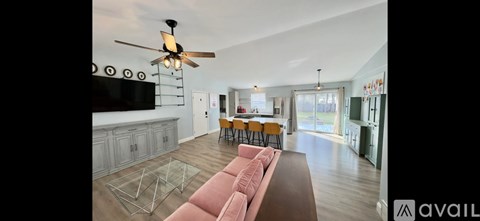 A living room with a pink couch and a ceiling fan.