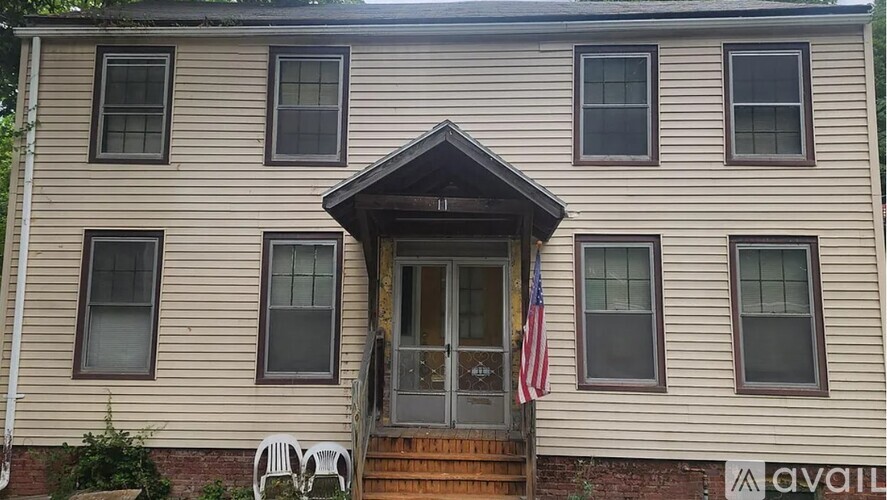 A house with a brown door and a small American flag hanging on it.