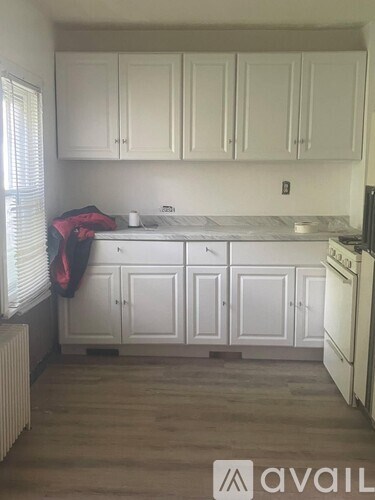 A kitchen with white cabinets and a marble countertop.