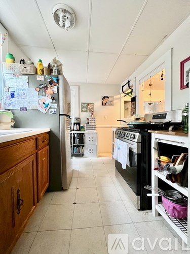 A kitchen with a black oven and a white fridge.