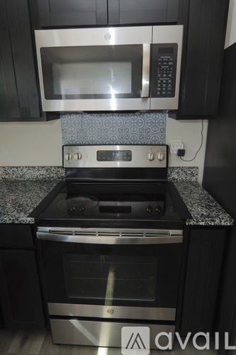 A modern kitchen with a stainless steel oven and microwave.