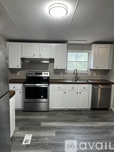 A kitchen with white cabinets and a stainless steel refrigerator.