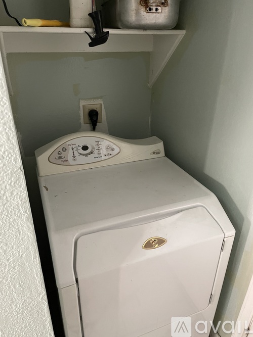A white washing machine in a small laundry room.
