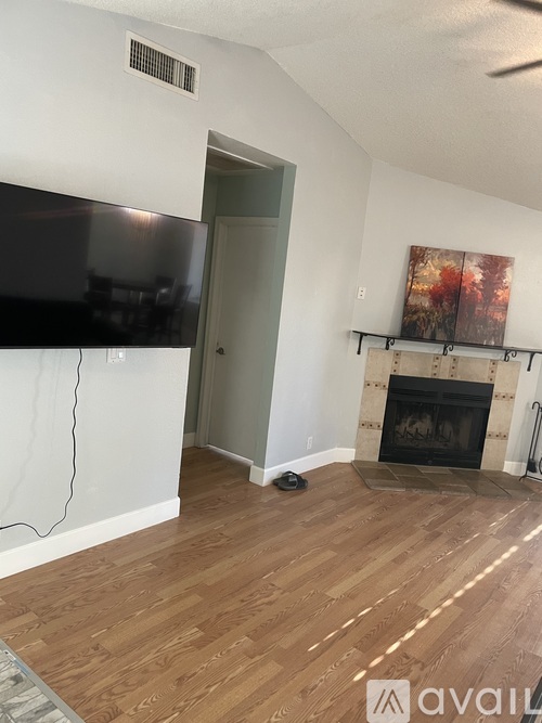 A living room with a fireplace and a television.