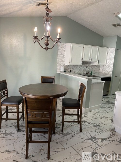 A kitchen with a table and chairs in the foreground.