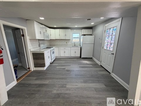 A kitchen with grey cabinets and a grey floor.