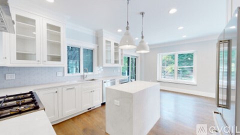 A modern kitchen with white cabinets and a central island.