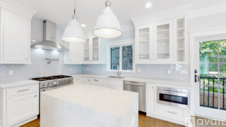 A kitchen with white cabinets and appliances.
