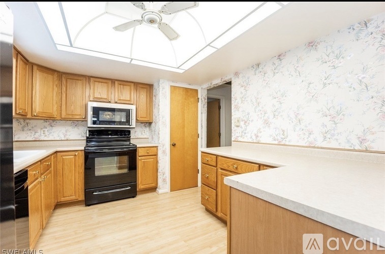 A kitchen with wooden cabinets and a black stove top oven.