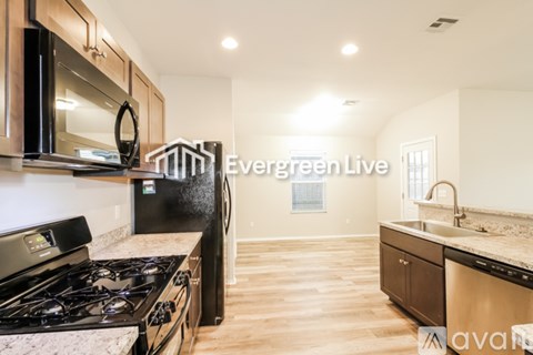 A kitchen with a black stove top oven and a black microwave.