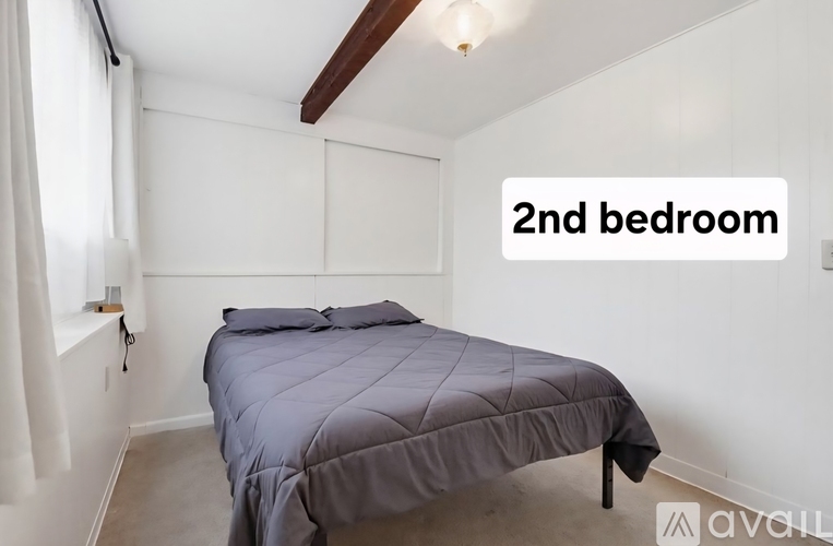 A bedroom with a bed and a window.