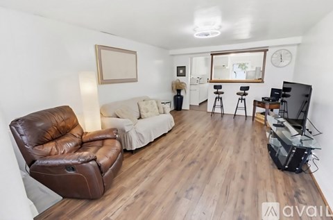 A living room with a brown leather chair and a white couch.