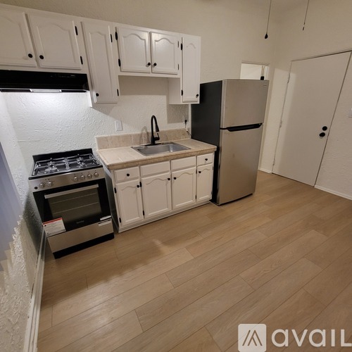 A kitchen with white cabinets and a black stove top oven.