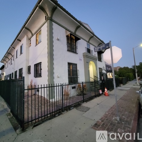 A white building with a black fence in front of it.
