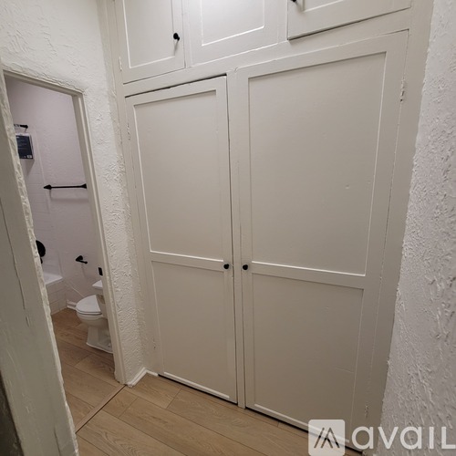 A white bathroom with a toilet and a white door.