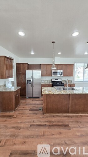 A kitchen with wooden floors and a countertop with a microwave and toaster oven.